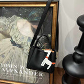 شنطة كتف سوداء أنيقة بتصميم عصري ودلايه حصان صغير - KSA